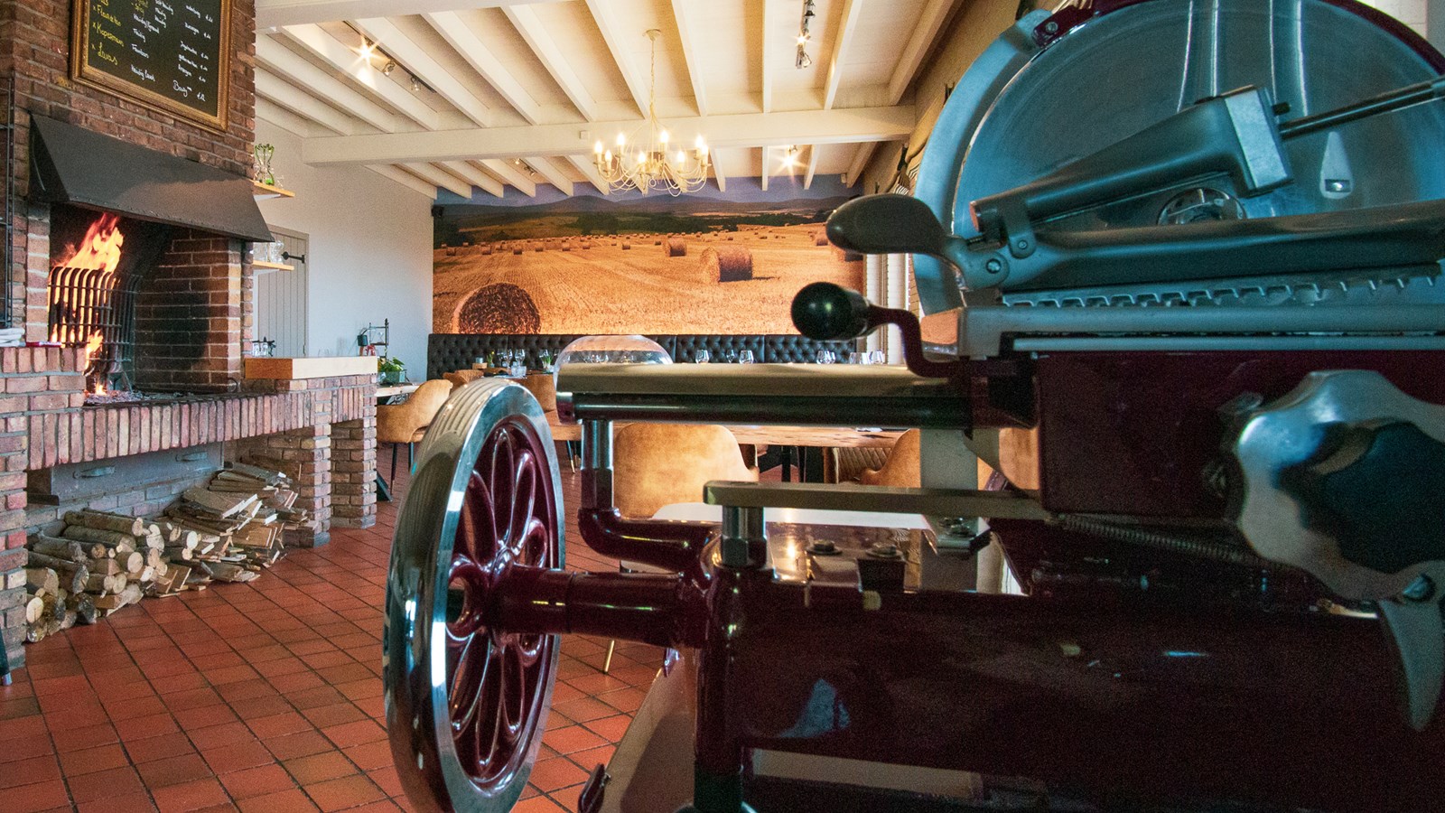 Restaurant Kapelle, interieur met haardvuur en vintage vleessnijmachine